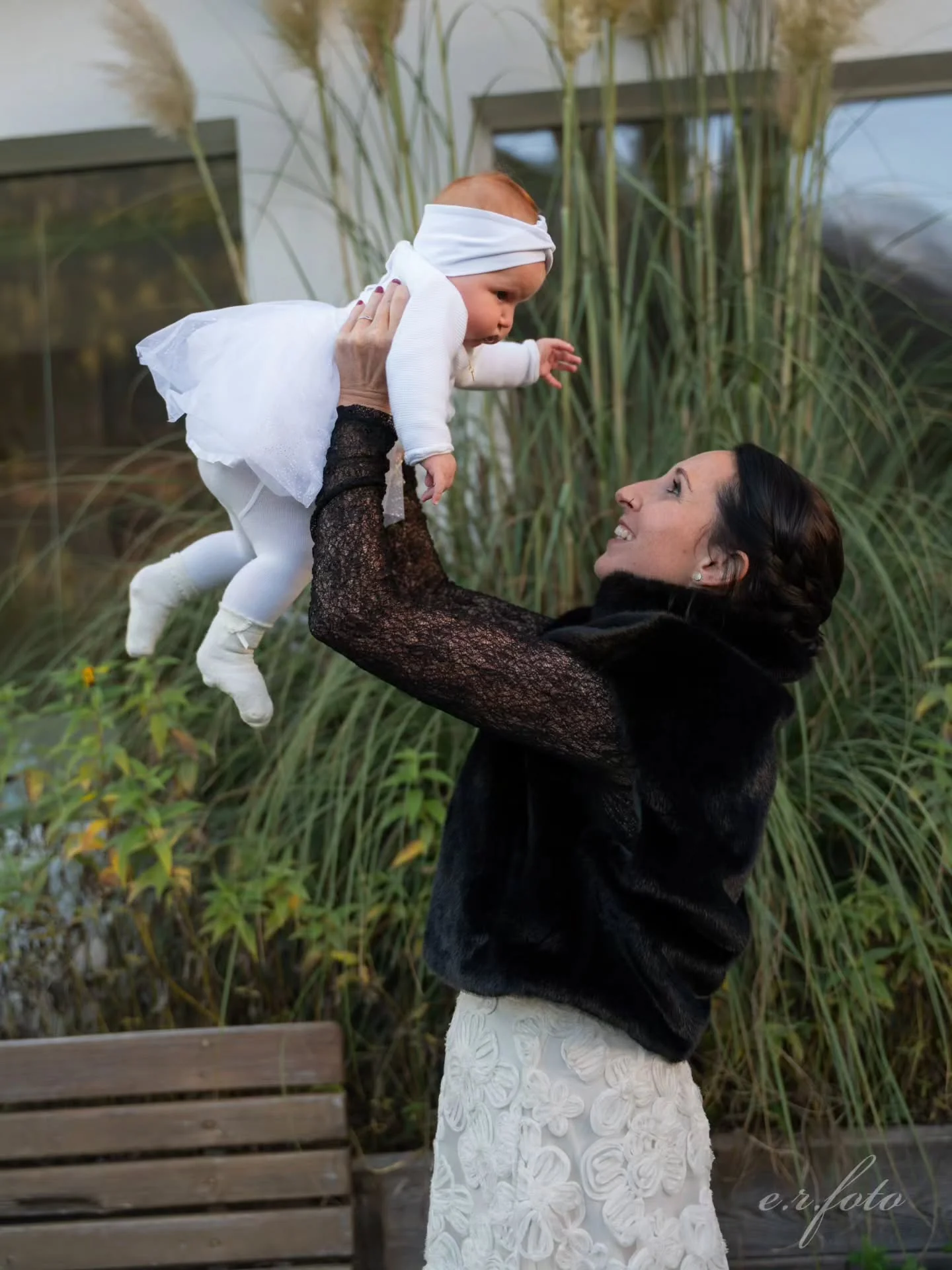 Madre solleva il suo bambino dopo il battesimo