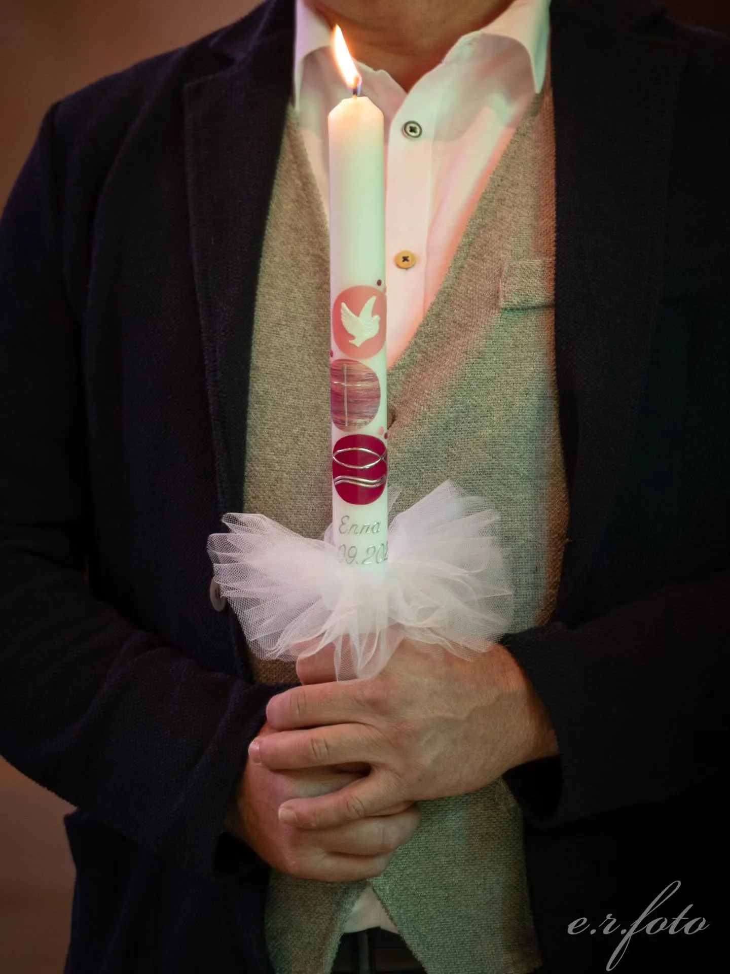 Candela del battesimo accesa nelle mani di un familiare